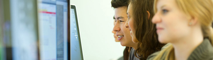 Students lookng into computer screen