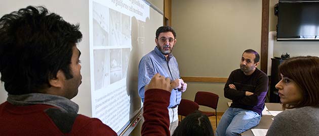 several faculty discussing a projector display