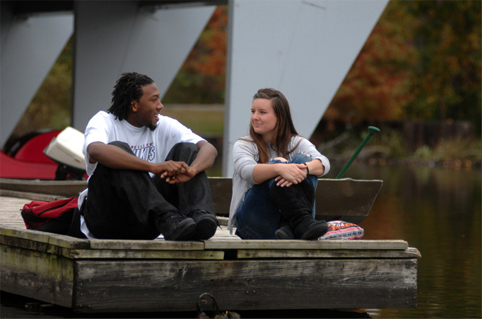 Two students sitting by Campus Lake